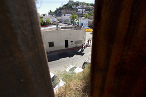 View through metal bars overlooking street with sidewalk on other side