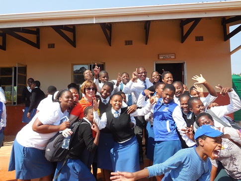 Shari Brink and fellow-traveler Jordan Banks celebrate with kids at Matamzama Dube High School where the Collegiate Churches have built three classrooms.