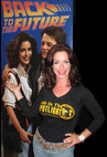 Claudia Wells posing with banner